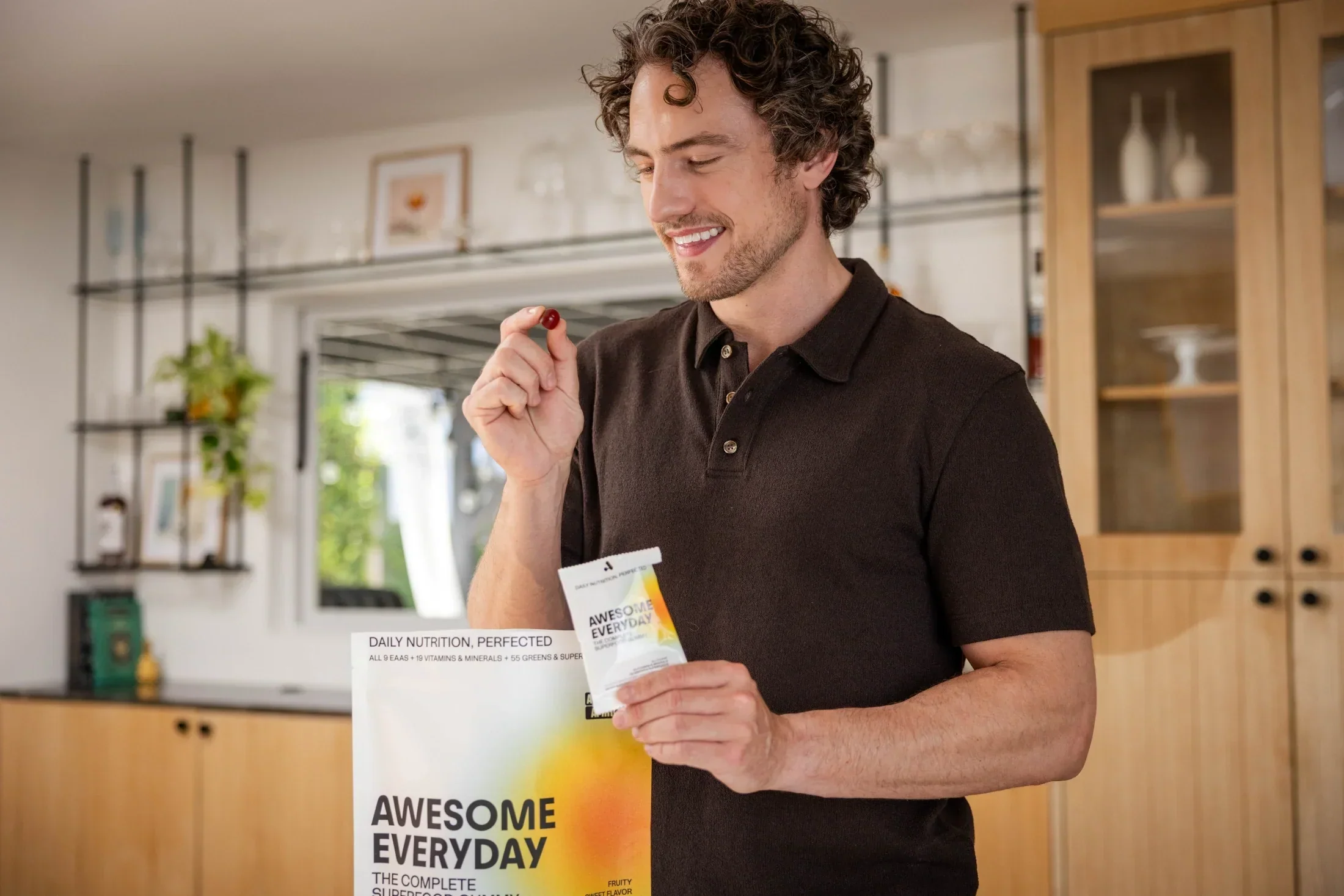 Person smiling and holding an Awesome Everyday™ gummy and pouch.