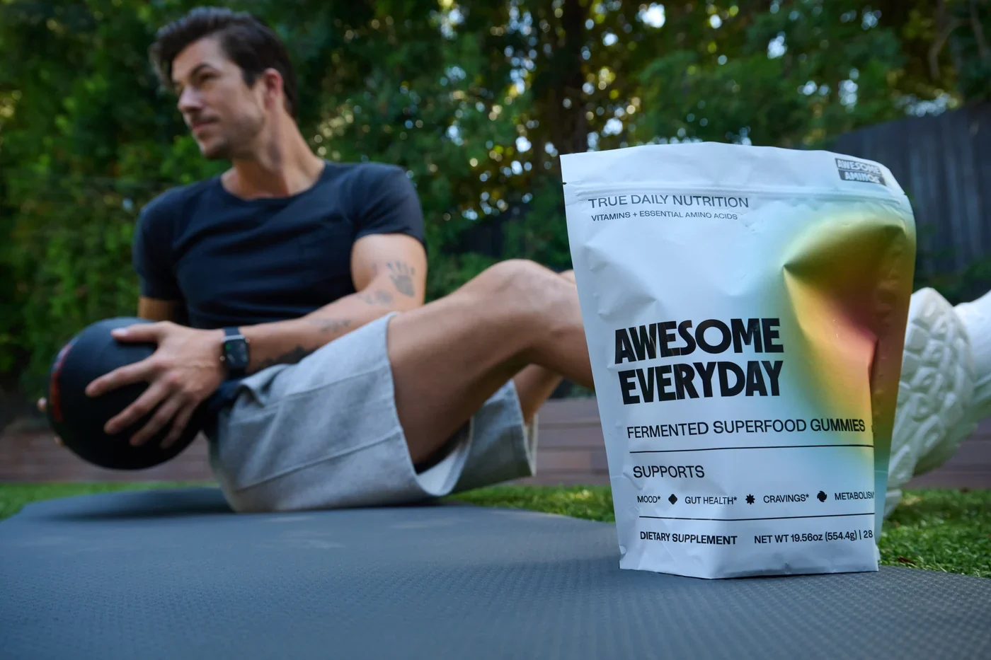 Man exercising outdoors beside an Awesome Everyday™ gummy pouch.