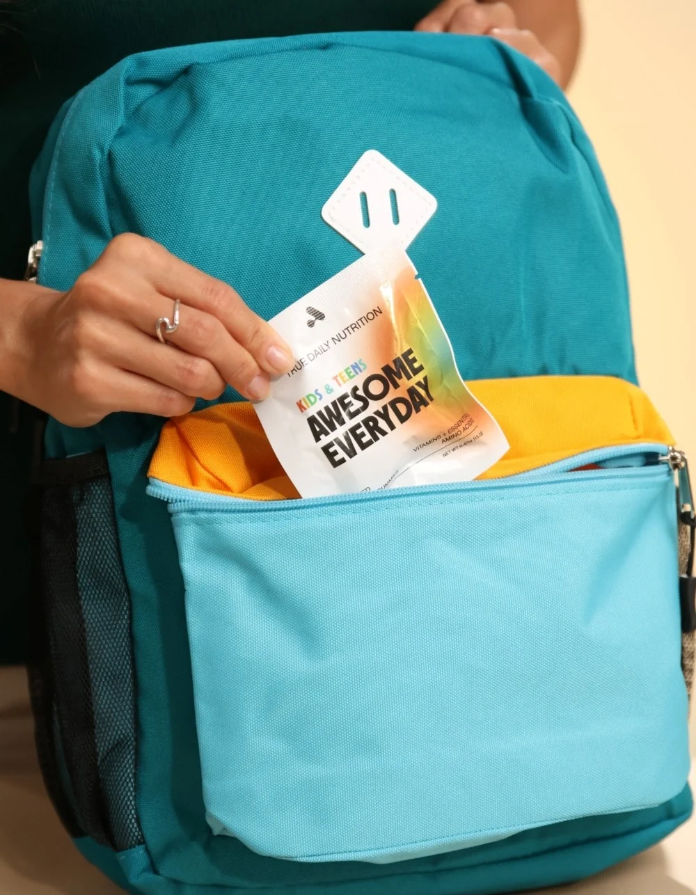 Awesome Everyday Kids & Teens packet tucked into a blue backpack for simple school-day nutrition.